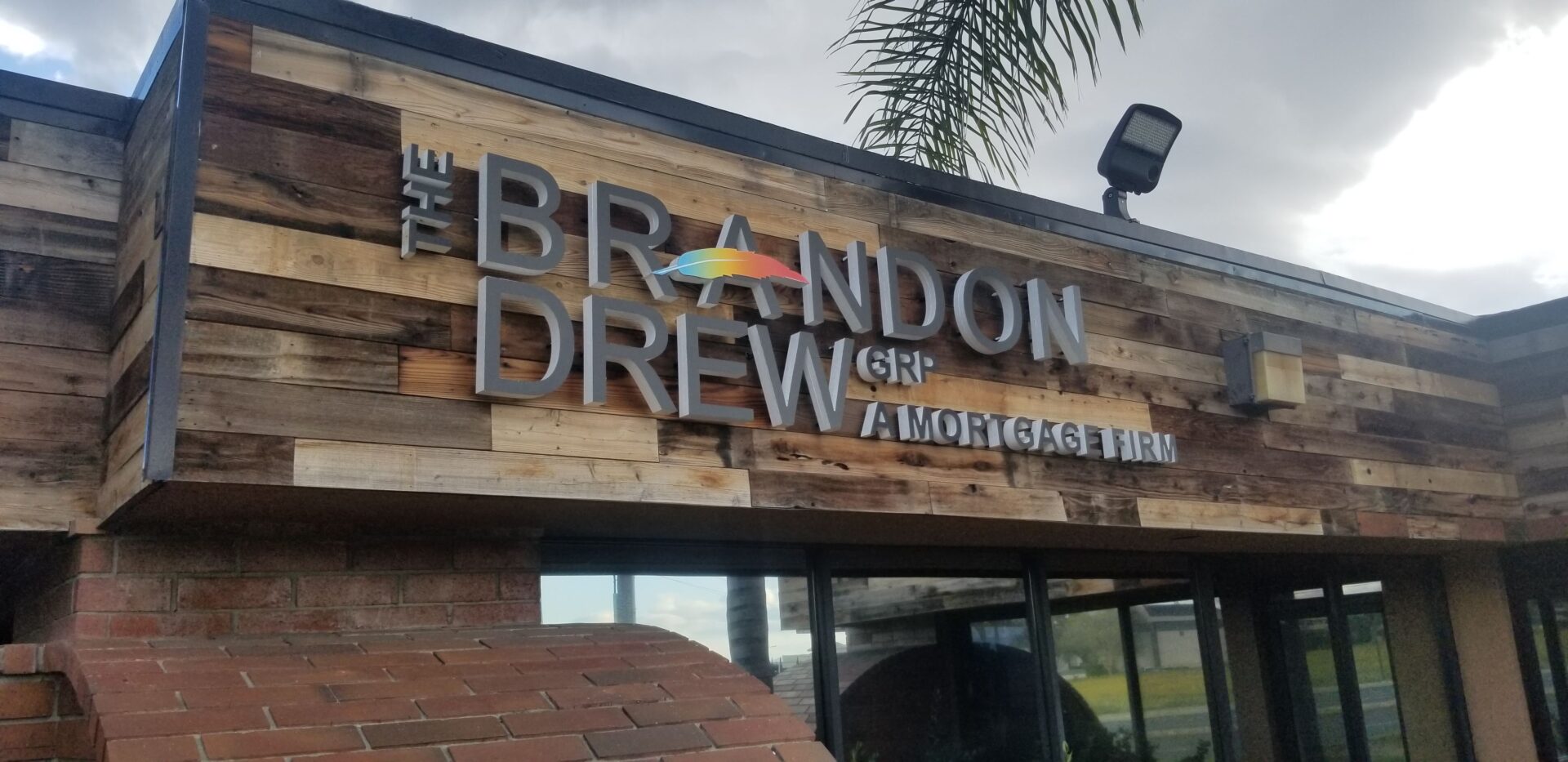Embossed grey signage of The Brandon Drew Grp